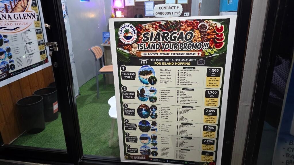 Tour price board at a General Luna travel agency showing Tri-Island at ₱1,399, Land Tour at ₱1,799 and Sohoton at ₱2,499 per person